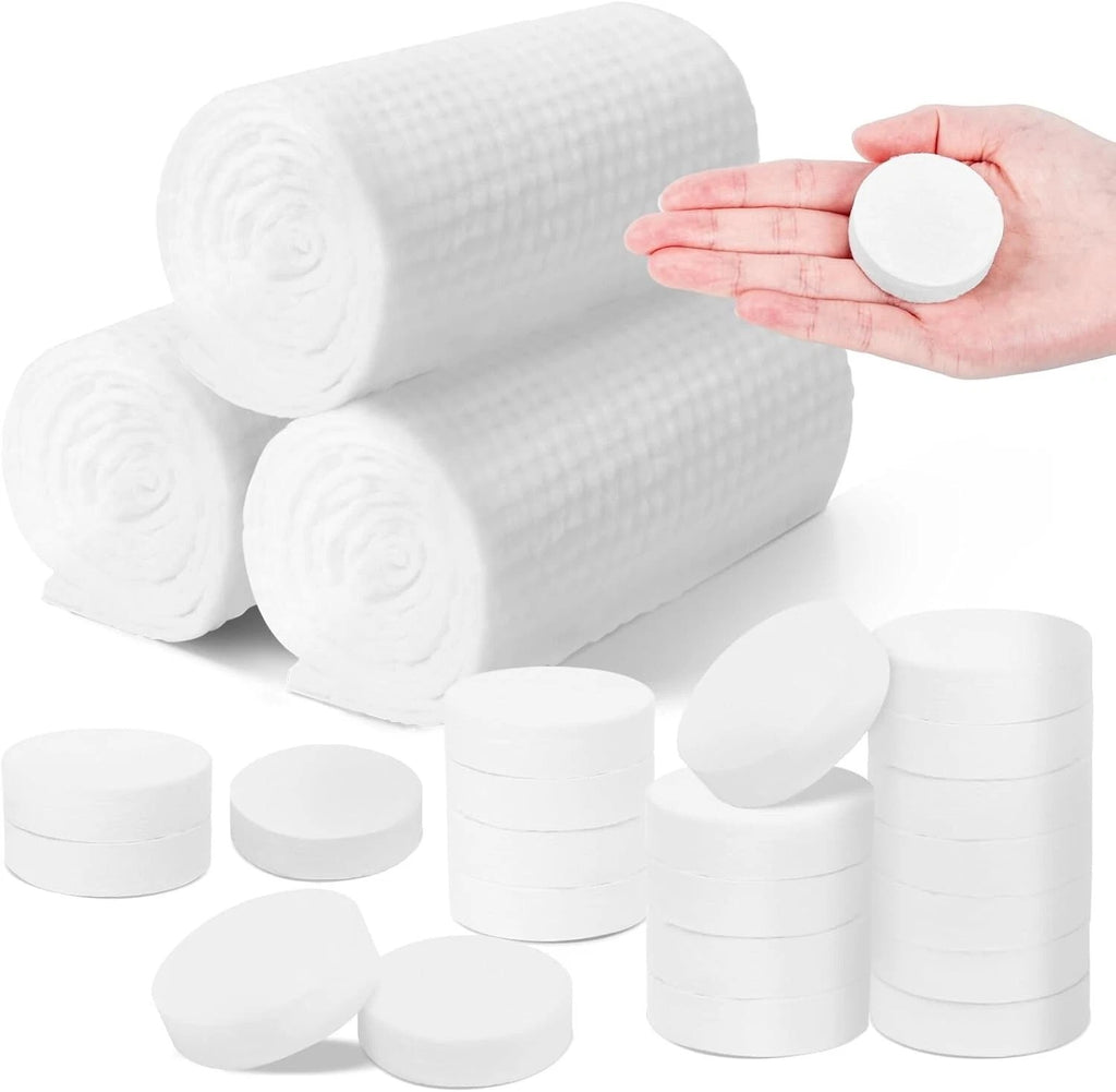 Gerollte Einweghandtücher und komprimierte Handtuchtabletten, eine Tablette in einer Hand
